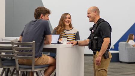 Officer talking to students in the Steven Student Center